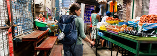 A traveler with backpack browsing in a market
