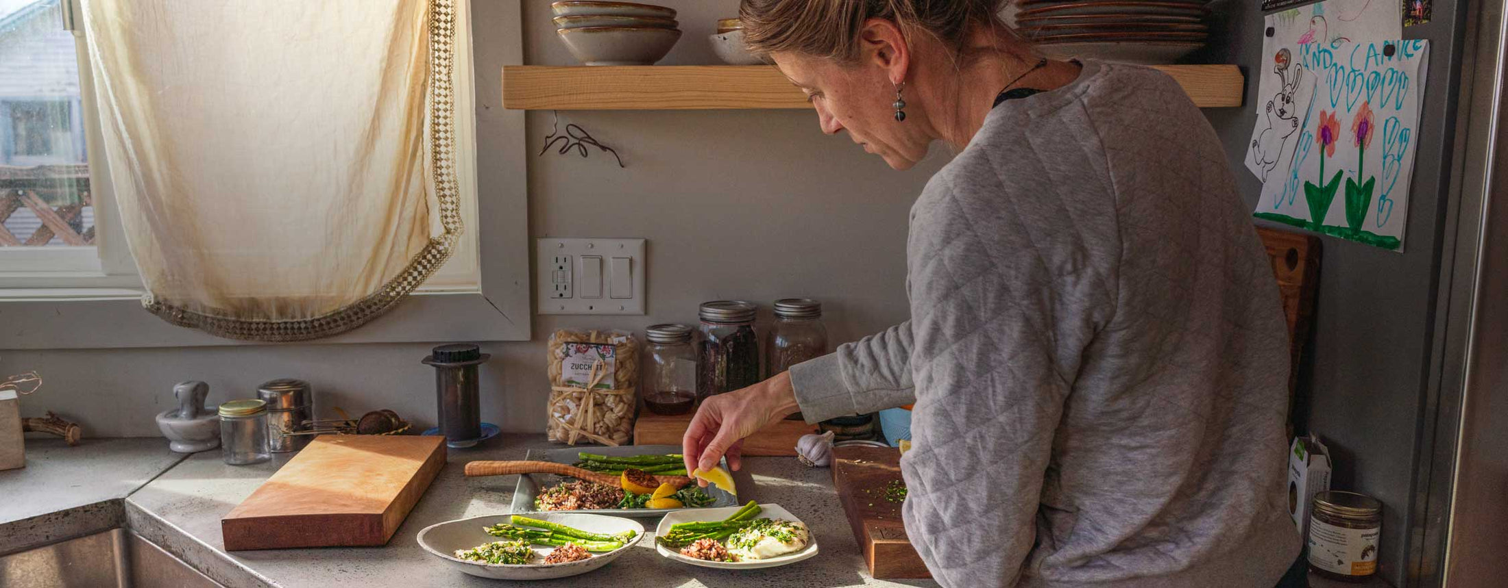 A home chef prepares plates of grilled vegetables topped with chimichurri sauce