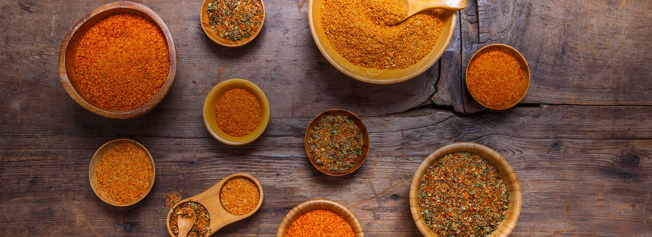 A wooden table with small wooden bowls filled with warm toned ground Patagonia Provisions Spices