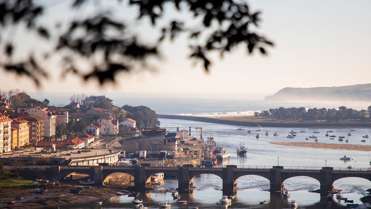 The village of San Vicente de la Barquera from a distance, with bridge and boats