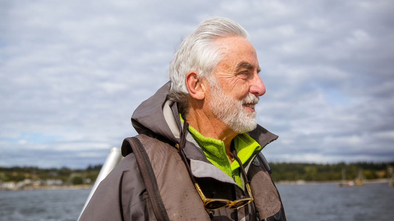 Kurt Beardslee stands in profile with the water and shoreline behind him
