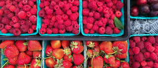 Baskets of raspberries and strawberries packed closely together
