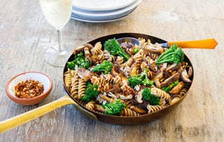 A warm pan filled with dinner - fusilli pasta, broccolini and shitake mushrooms. 