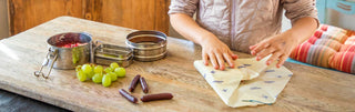 A young person uses tins and Bees Wrap to prep a meal to go with fresh fruit and Patagonia Provisions snacks
