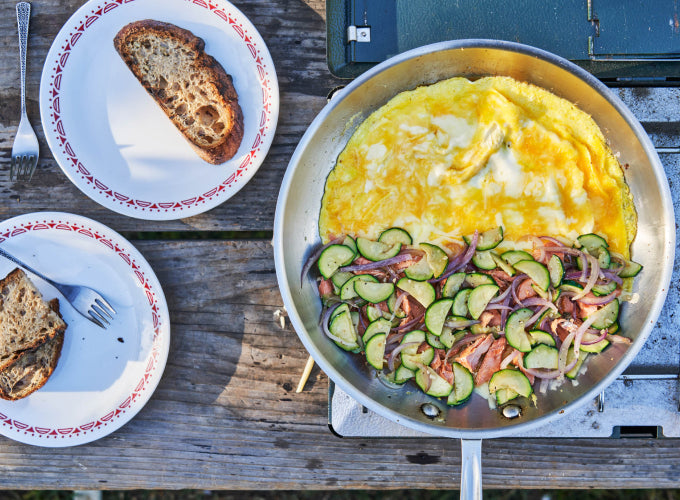 A skillet on a camp stove cooks up an omelet with vegetables and Patagonia Provisions Smoked Salmon