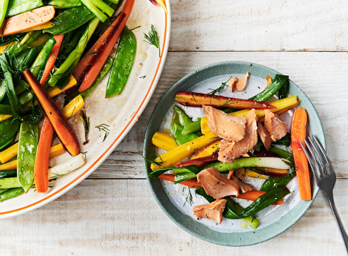 A ceramic bowl and plate serve fresh and roasted vegetables topped with Patagonia Provisions Wild Smoked Salmon