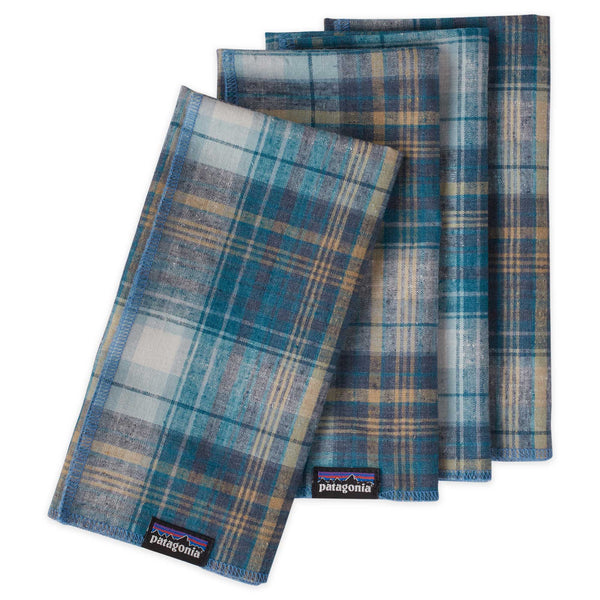 A set of four Patagonia recycled cloth napkins in a blue plaid with the top napkin set at an angle
